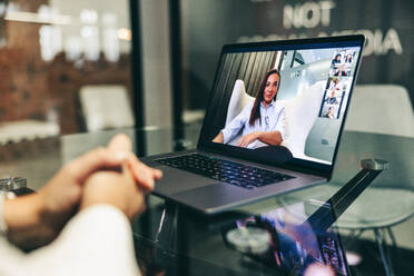 Anonymous businesswoman attending a virtual meeting in a modern workplace. Unrecognisable businesswoman using a laptop to video call her business partners. Female entrepreneur doing global business. - JLPSF07692