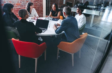 Diskussion im Besprechungsraum. Eine Gruppe von kreativen Geschäftsleuten diskutiert während ihrer morgendlichen Besprechung in einem modernen Büro. Geschäftsleute arbeiten als Team zusammen. - JLPSF07975