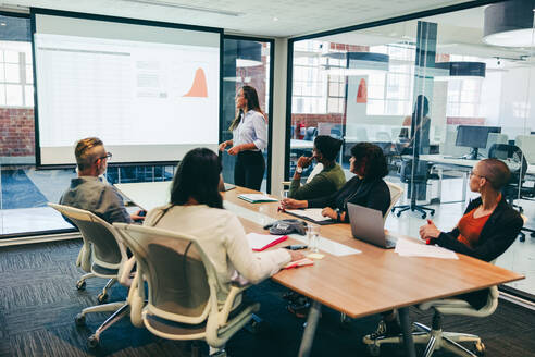 Team of creative businesspeople having a presentation in a boardroom. Group of modern businesspeople attending a financial briefing in a modern workplace. Businesspeople analysing statistical details. - JLPSF08083