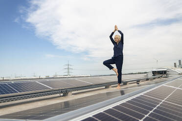 Ältere Geschäftsfrau macht Yoga im Solarkraftwerk - JOSEF14177