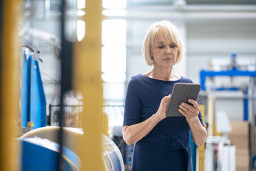 Geschäftsfrau benutzt Tablet-PC in der Industrie - JOSEF14258