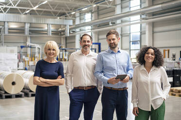 Smiling business colleagues standing in industry - JOSEF14315
