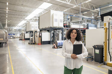 Businesswoman holding laptop in industry - JOSEF14394