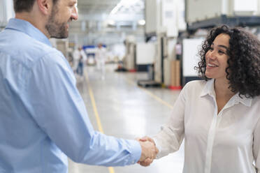 Smiling businesswoman shaking hand with businessman - JOSEF14405