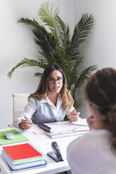 Young lawyer discussing with client in office - JAQF01064