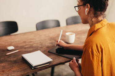 Designerin bei der Arbeit an einem digitalen Tablet. Frau arbeitet von zu Hause aus mit digitalisiertem Stift und Tablet-PC. - JLPSF08121