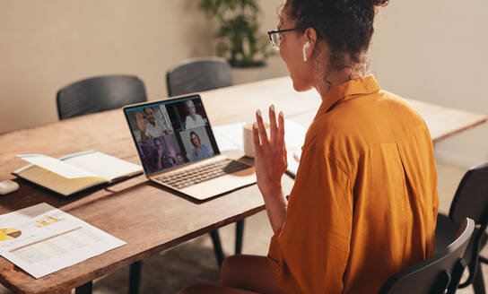 Geschäftsfrau, die zu Hause eine Videokonferenz mit Kollegen abhält. Frau, die ihren Kollegen während einer Webkonferenz begrüßt. - JLPSF08123