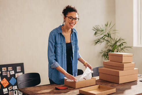 Frau Online-Geschäft Unternehmer Verpackung Paketkasten im Büro zu Hause. Frau Verkäufer Vorbereitung Produkt für die Lieferung. - JLPSF08140