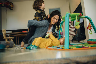 Woman playing with her kids at home. Mother taking care of her two kids at home. - JLPSF08153