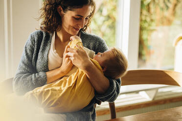 Mutter gibt ihrem Baby zu Hause Milch aus der Flasche. Baby trinkt Milch aus der Flasche. - JLPSF08253