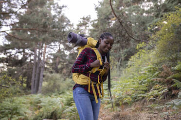 Glückliche Frau mit Rucksack beim Wandern im Wald - JCCMF07471