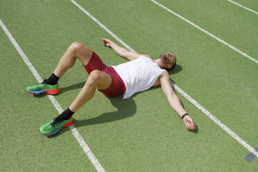 Athlete relaxing on running track - IFRF01838