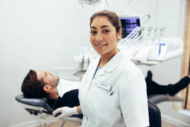 Porträt einer Ärztin mit Patient im Zahnarztstuhl. Selbstbewusste Zahnärztin in ihrer Klinik. - JLPSF08441