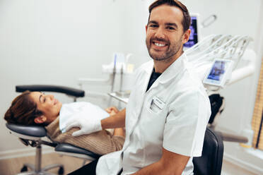 Successful male dentist in his clinic. Dental expert with female patient at dentistry. - JLPSF08459