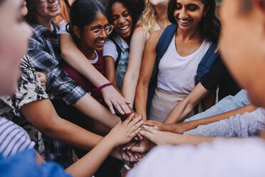 Eine Gruppe multikultureller Jugendlicher, die sich glücklich lächelnd an den Händen fassen. Die junge Generation Z symbolisiert Gemeinschaft und Teamwork. - JLPSF08569