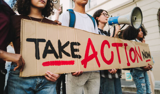 Multicultural youth activists standing up for equality and human rights. Generation Z calling for action and change. Group of diverse young people protesting with a banner and a megaphone. - JLPSF08608