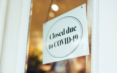 Ein Schild an der Glastür zeigt an, dass das Geschäft wegen Covid-19 geschlossen ist. Kleine Geschäfte sind wegen der Pandemie geschlossen. - JLPSF08642