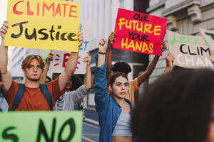 Junge Menschen demonstrieren gegen den Klimawandel und die globale Erwärmung. Multikulturelle Klimaaktivisten protestieren mit Plakaten und Transparenten. Eine Gruppe Jugendlicher schließt sich dem globalen Klimastreik an. - JLPSF08826