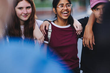 Group of happy teenage activists embracing each other and standing in a circle. Multicultural young people campaigning for equality and diversity. - JLPSF08830