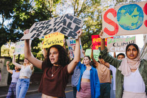 Eine Gruppe Jugendlicher, die sich gegen den Klimawandel und die globale Erwärmung wehrt. Multikulturelle jugendliche Aktivisten protestieren mit Plakaten und Spruchbändern. Verschiedene Jugendliche schließen sich dem globalen Klimastreik an. - JLPSF08841