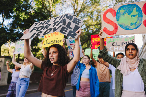 Eine Gruppe Jugendlicher, die sich gegen den Klimawandel und die globale Erwärmung wehrt. Multikulturelle jugendliche Aktivisten protestieren mit Plakaten und Spruchbändern. Verschiedene Jugendliche schließen sich dem globalen Klimastreik an. - JLPSF08841