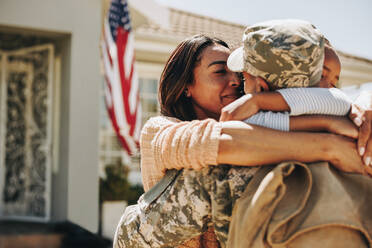 Ein amerikanischer Soldat verabschiedet sich von seiner Familie zu Hause. Ein tapferer Soldat umarmt seine Frau und seine Tochter, bevor er in den Krieg zieht. Ein patriotischer Mann geht, um seinem Land im Militär zu dienen. - JLPSF09045