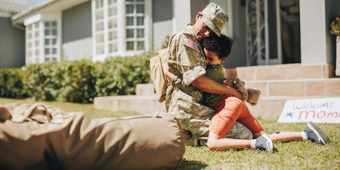 Ein kleiner Junge umarmt seine Mutter bei ihrer Heimkehr. Eine Mutter aus dem Militär erlebt ein emotionales Wiedersehen mit ihrem Sohn, nachdem sie in der Armee gedient hat. - JLPSF09070