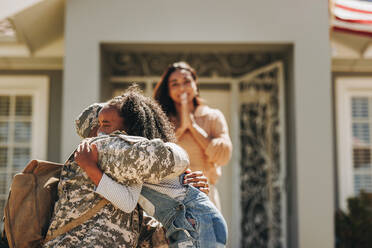 Militärischer Mann, der sich von seiner Familie verabschiedet, bevor er in den Krieg zieht. Amerikanischer Soldat, der seine Tochter umarmt. Patriotischer Soldat, der seine Familie verlässt, um seinem Land in der Armee zu dienen. - JLPSF09098