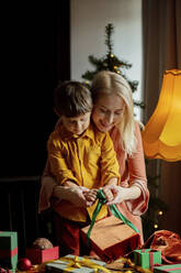 Mutter bringt ihrem Sohn bei, wie man Geschenke zu Hause einpackt - VSNF00011