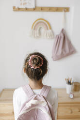 Rückansicht eines Mädchens mit rosa Rucksack und Haarknoten - SSYF00004