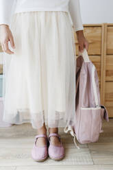 Girl holding pink backpack wearing matching shoes - SSYF00005