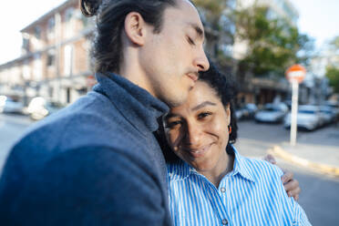 Smiling woman by boyfriend with eyes closed on street - JOSEF14512