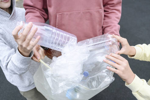 Hands of man and children collecting plastic garbage - EYAF02188