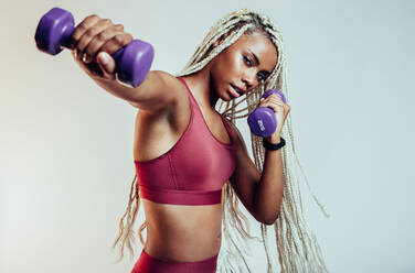 Fit woman working out at the gym with dumbbells stock photo