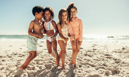 Happy little kids smiling cheerfully while playing together at the each. Group of adorable young friends having fun together during summer vacation. - JLPSF09963