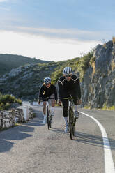 Sportler und Sportlerin beim Radfahren auf dem Bergpass der Costa Blanca in Alicante, Spanien - AMNF00003