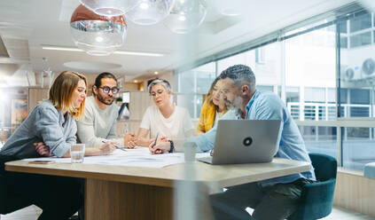 Verschiedene Designer beim Brainstorming während einer Besprechung in einem modernen Büro. Ein Team innovativer Geschäftsleute diskutiert während der Arbeit an einem neuen kreativen Projekt. - JLPSF10155