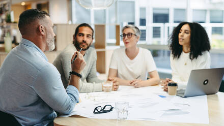 Group of design professionals having a discussion during a meeting in the office. Team of innovative businesspeople sharing creative ideas while working on a new project. - JLPSF10217