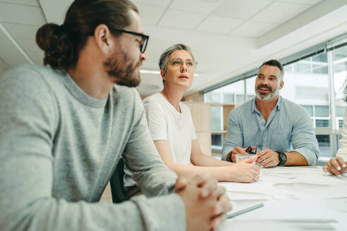 Kreative Geschäftsleute bei einer Besprechung in einem modernen Büro. Eine Gruppe innovativer Geschäftsleute arbeitet mit Plänen. Ein Team von Ingenieuren plant ein neues Projekt. - JLPSF10251