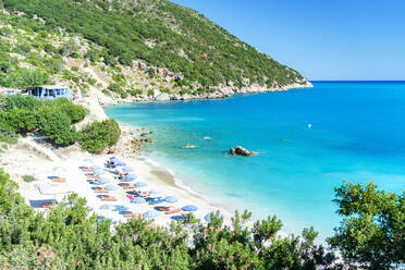 Blick von oben auf Sonnenschirme am idyllischen Strand von Vouti, eingerahmt von üppigen Pflanzen, Zola, Kefalonia, Ionische Inseln, Griechische Inseln, Griechenland, Europa - RHPLF23259