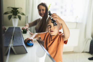 Junge spielt mit Spielzeugautos bei seiner Mutter im heimischen Wohnzimmer - DMMF00184