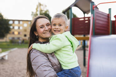 Smiling mother and son in park - DMMF00200