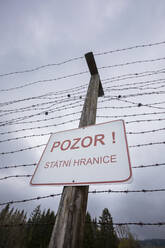 Austria, Upper Austria, Warning sign on barbed wire fence of Iron Curtain Memorial - WWF06210