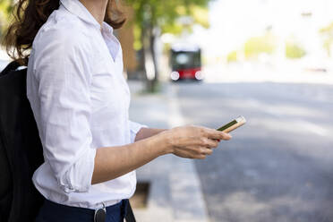 Geschäftsfrau mit Smartphone am Fußweg - WPEF06586