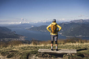 Woman with hands on hip standing in front of mountains - UUF27628