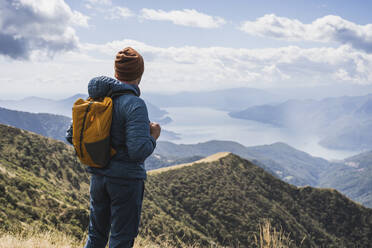 Man wearing knit hat standing in front of mountains at vacation - UUF27654