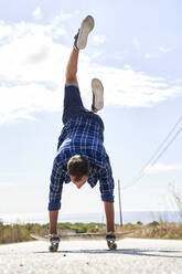Man practicing handstand on skateboard - VEGF06046