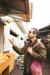 Mann fängt Grapefruit auf dem Markt - ACTF00252