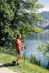 Young woman standing near Lake Levico on sunny day - GIOF15561