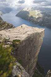 Hiker on majestic Pulpit rock by fjord in Lysefjorden, Norway - JAQF01076